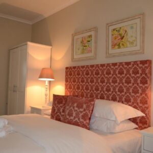 The Winelands Guest House: a bedroom with a large white bed with two lamps