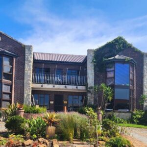 The Wooden Leg Guesthouse: a large brick building with a flag in front of it