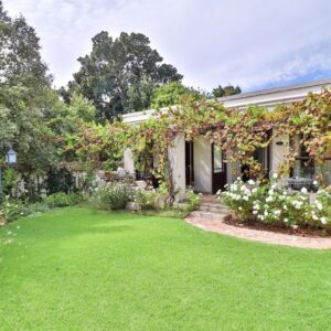 Three Oaks: a house with a lawn in front of it