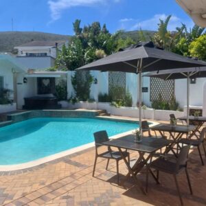 Thyme Wellness Spa and Guesthouse: a pool with two tables and an umbrella