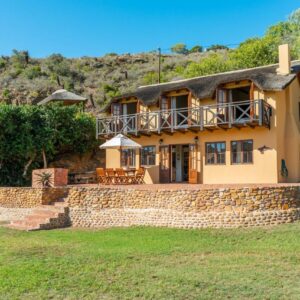 Tides River Lodge: a house on a hill with a stone wall