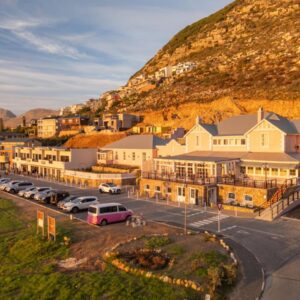 Tintswalo Summer House: a town with cars parked in front of a mountain