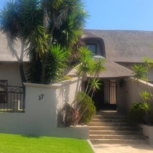 Traduire: a house with palm trees in front of it