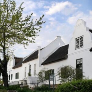 Tulbagh Country Guest House - Cape Dutch Quarters: a white house with black windows and a tree