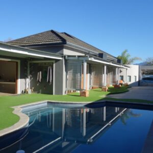Two Fat Owls Guesthouse: a house with a swimming pool in front of a house