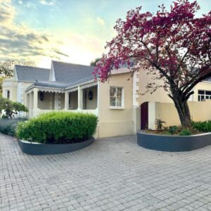 Uniondale Guest Lodge: a white house with a tree in front of it