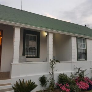 Uniondale Manor Guesthouse: a small white house with a green roof