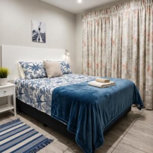 VD1 Ocean Room B&B: a bedroom with a bed with a blue blanket