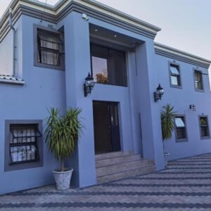 Victoria Guest Lodge: a blue house with plants in front of it