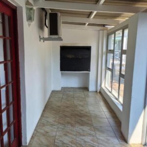 Victoria Oaks Beaufort West Guesthouse: a hallway of a house with a door and a television