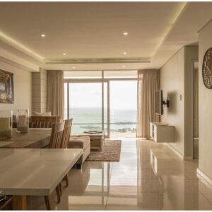 View @ The Bay Apartments: a dining room and living room with a view of the ocean