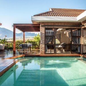 Wellington Country House: a house with a swimming pool and a patio