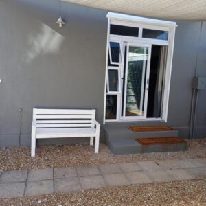 Wembley guesthouse: a white bench sitting in front of a door