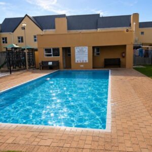 Wendy's Lodge: a large swimming pool in front of a house