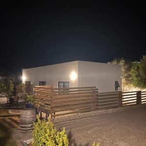 Westcoast Coastal Retreat: a building with a wooden fence in front of it at night