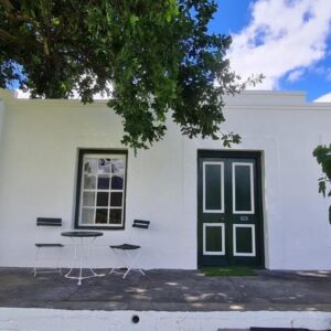 Whipstock Guest Farm: a white house with a table and chairs in front of it