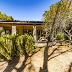 Wilderness Metanoia: a house with a fence and trees in front of it