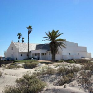 Zeezicht Apartments: a white house on the beach with palm trees